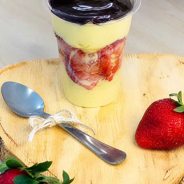 Bombom aberto no copo com creme, chocolate e morango